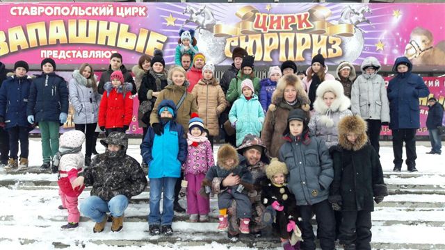 Посетители цирка на фоне афиши